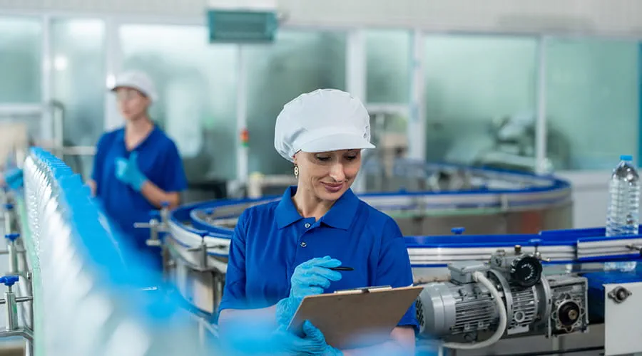 Equipo de trabajadoras de la industria alimenticia trabajando en el almacén de la fábrica