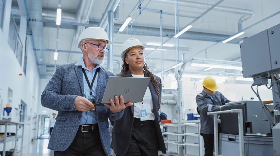 Dos ingenieros profesionales de la industria pesada con cascos en la fábrica