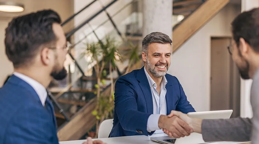 Empresarios se dan la mano después de una exitosa reunión en una oficina moderna