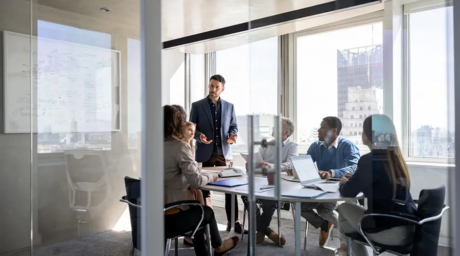 Hombre de negocios hablando con un grupo de personas en una reunión en la oficina