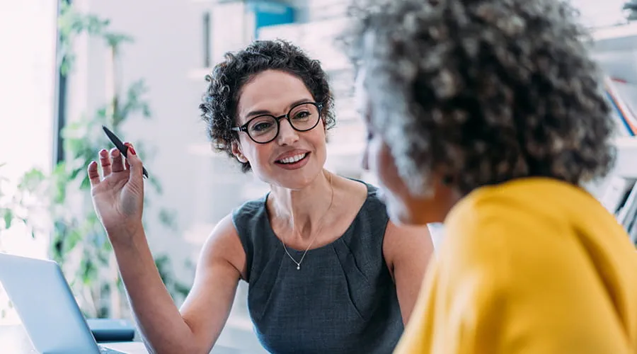 Dos mujeres hablando en una reunión de trabajo
