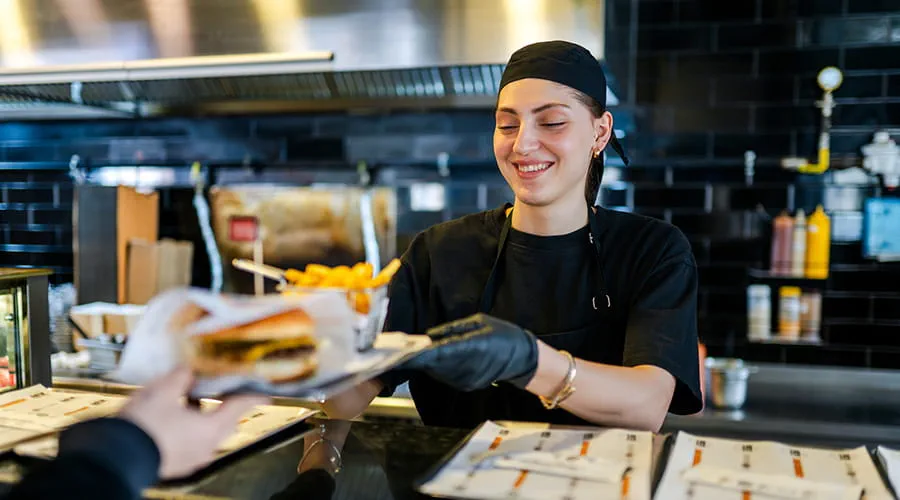 Joven trabajando en un restaurante de hamburguesas