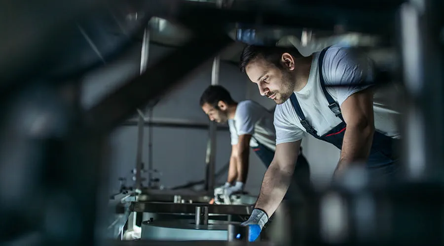 Trabajadores manuales trabajando en una máquina en una fábrica