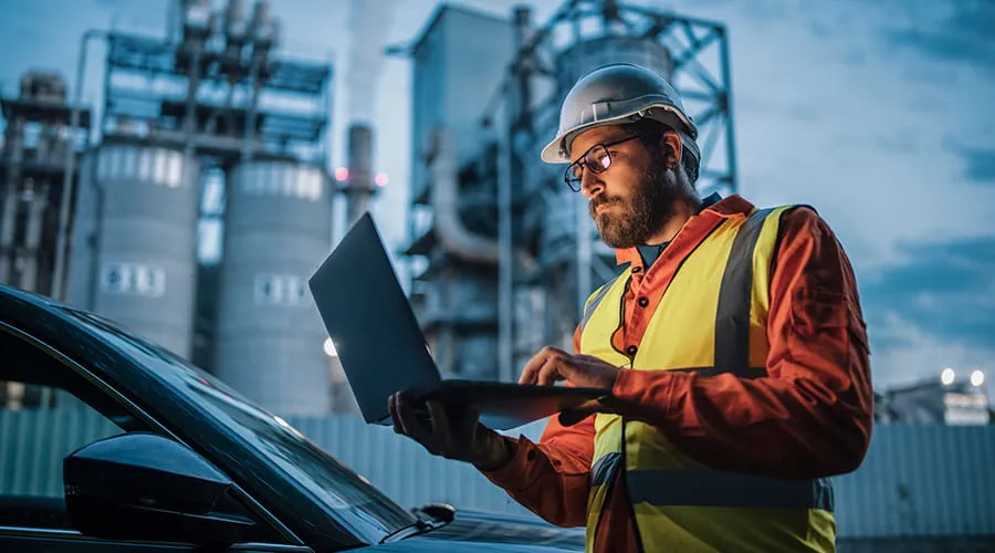 Ingeniero en entorno industrial utilizando un ordenador portátil