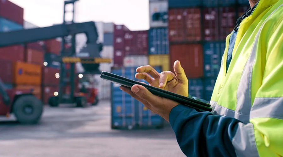 Hombre trabajando con una tablet en entorno puertos