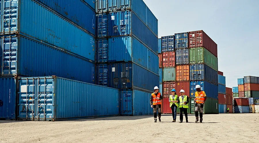 Grupo de personas cerca de contenedores en un puerto