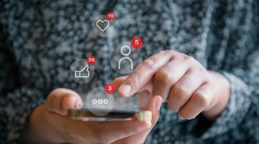 Manos de mujer utilizando las redes sociales a través de un teléfono inteligente