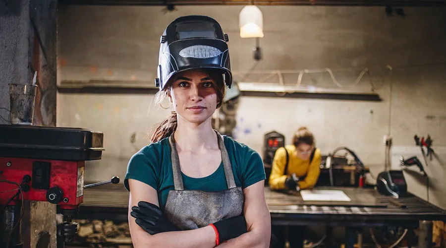 Mujer soldadora en un pequeño taller metal