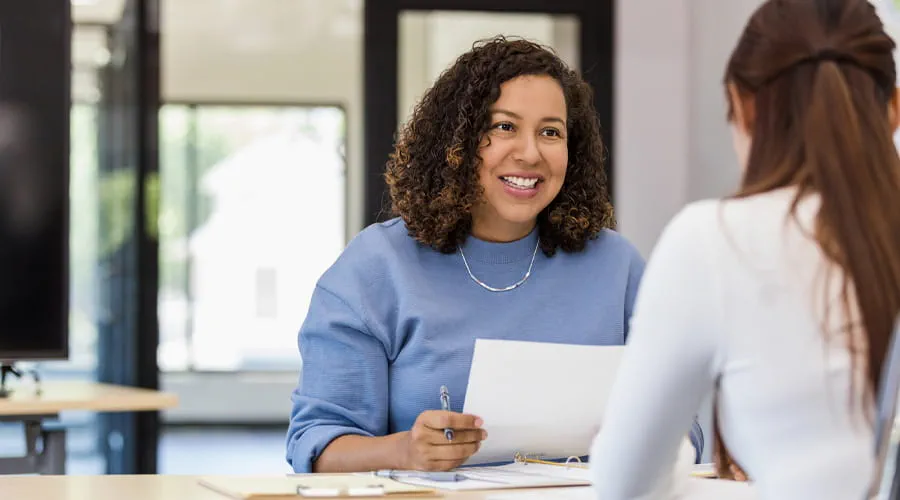 Mujer realiza una entrevista de trabajo a otra mujer