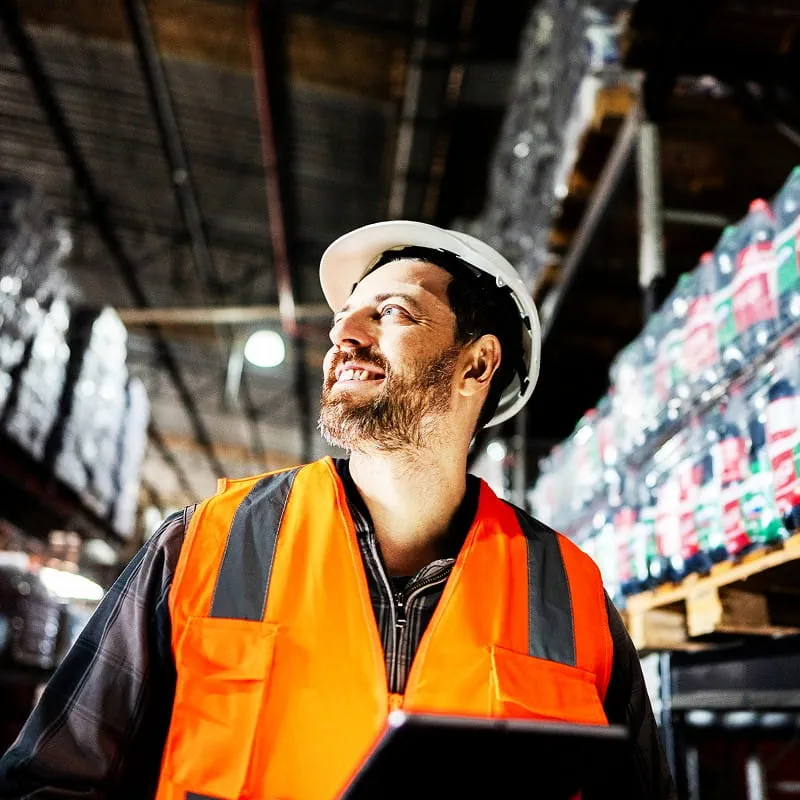 Un homme souriant travaillant sur un site logistique 
