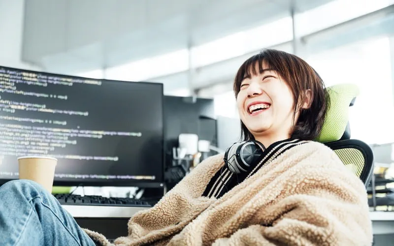 une salariée souriante travaillant dans le domaine technologique