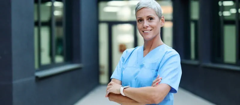 Une soignante souriante cumulant emploi et retraite 