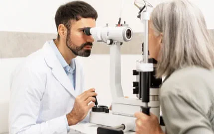 Ophtalmologue réalisant une consultation visuelle avec une patiente dans un cabinet d’ophtalmologie