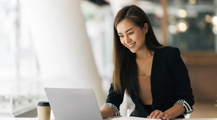 Young female professional working on a laptop at a modern desk