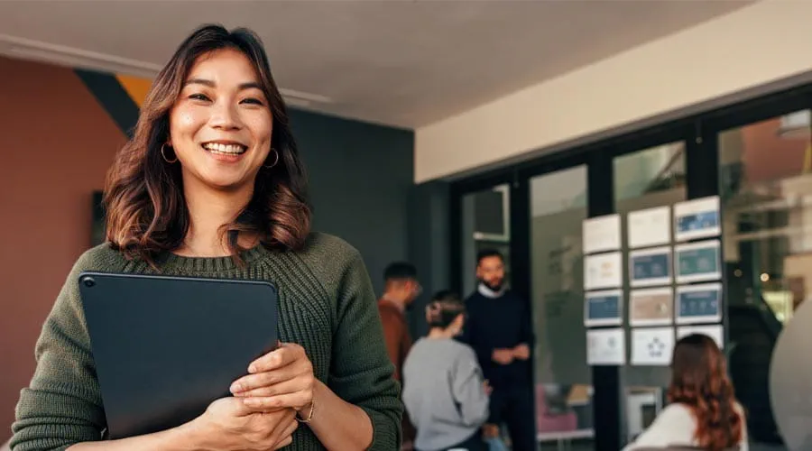 Smiling professional with a business meeting taking place in the background