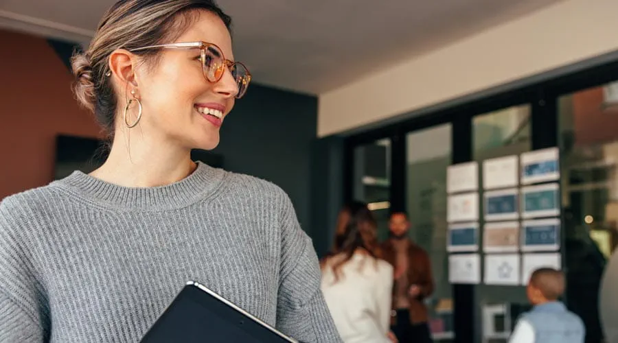 Smiling female  professional holding a  tablet in a modern office  setting