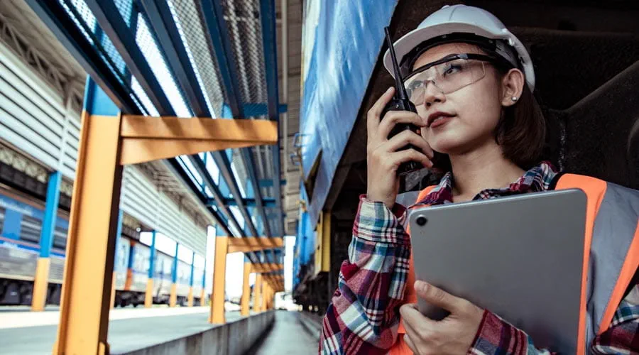 Female logistics worker  communicating using a  walkie talkie