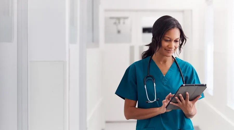 Nurse working on a tablet in a medical environment