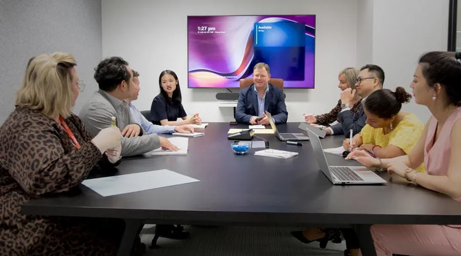 Adecco team in a formal boardroom meeting discussing strategies