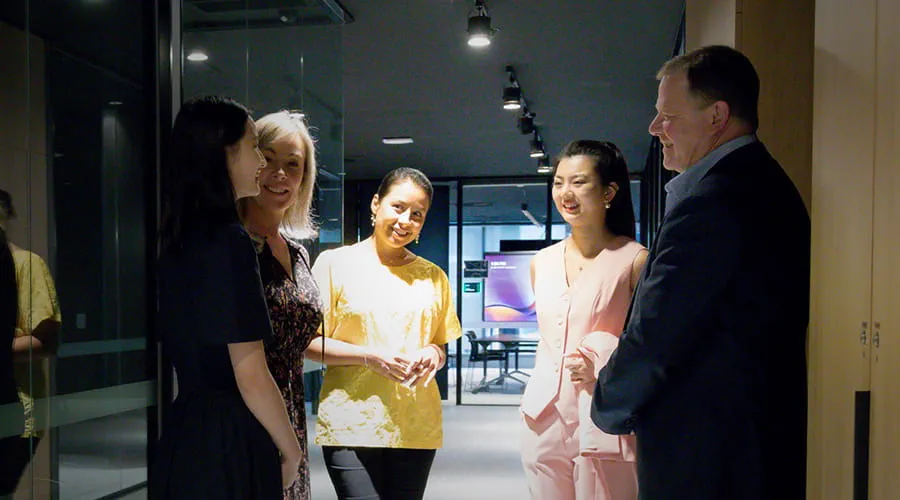Four colleagues having a discussion in a hallway.