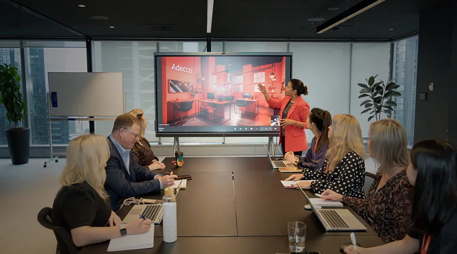 A group of staff seated around a table in a meeting room.