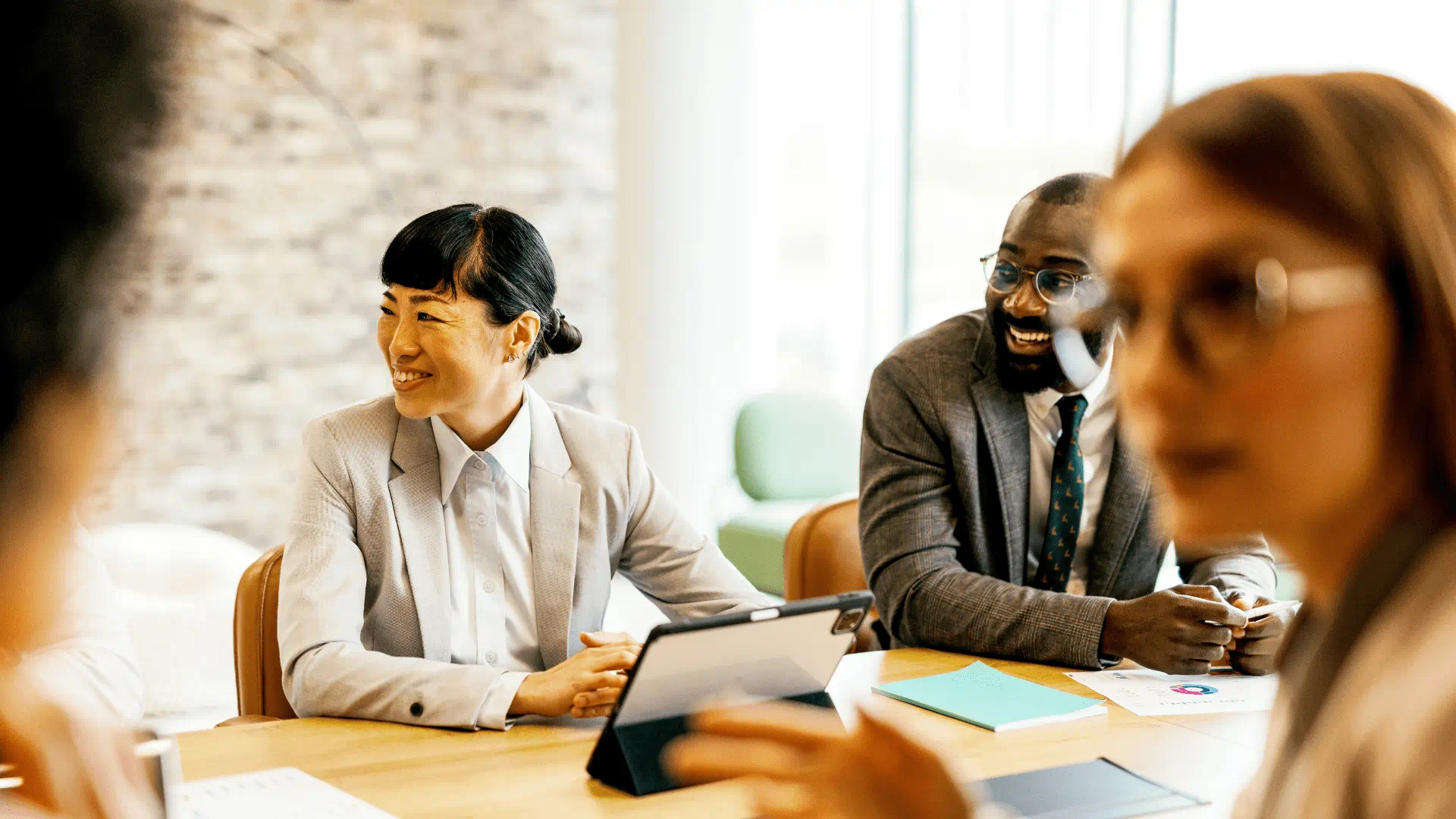 people working at a desk in a common work setting and smiling