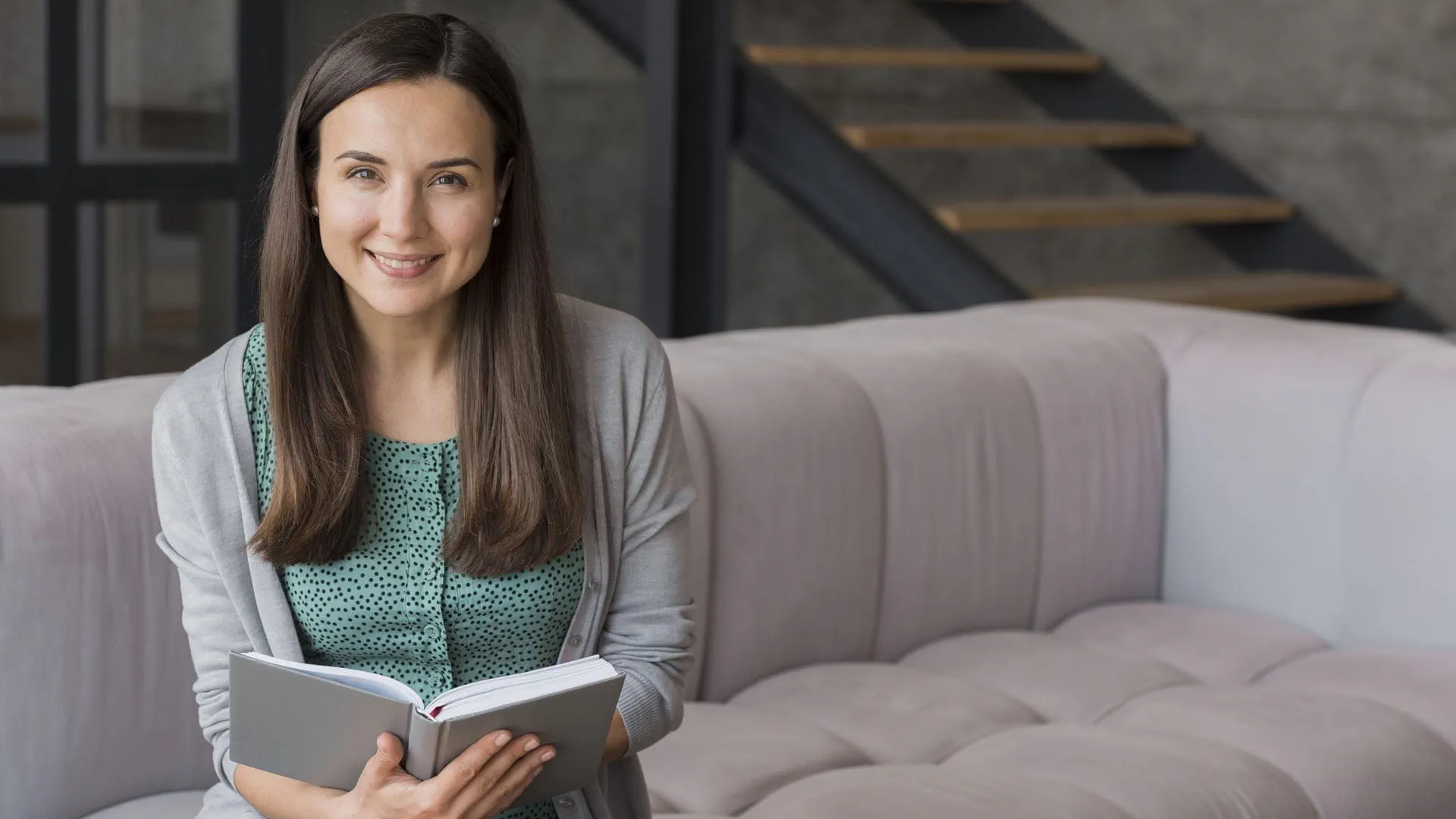mujer-sonriente-en-el-sofa-leyendo