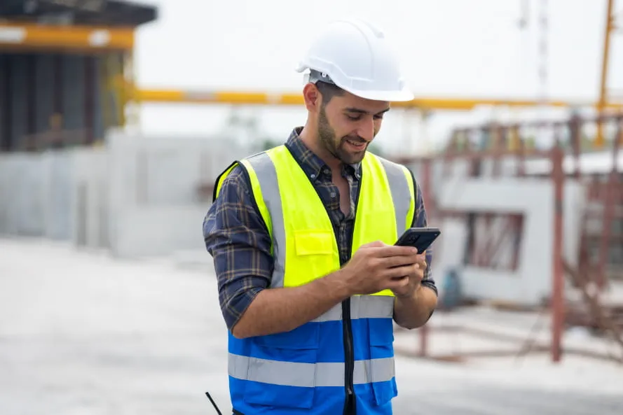 Mitarbeiter nutzt Adecco App auf der Baustelle