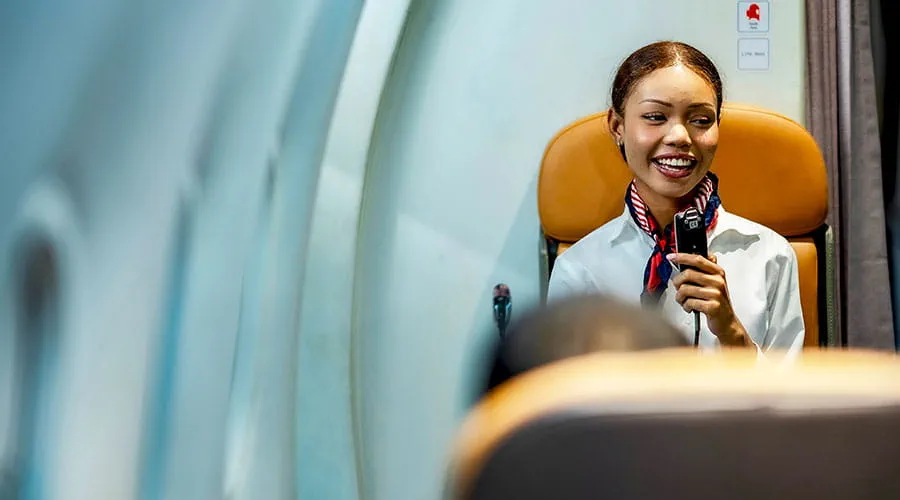 Flight attendant speaking to passengers onboard aircraft