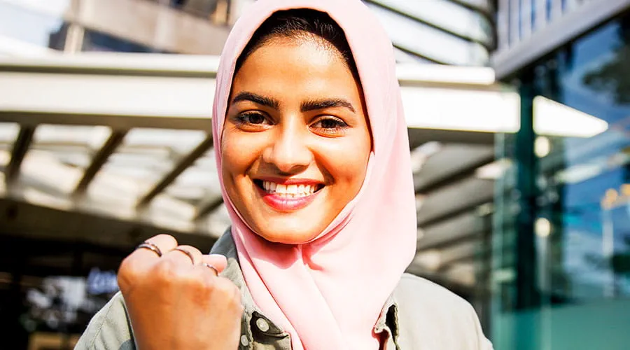 Woman smiling and taking selfie in workplace setting