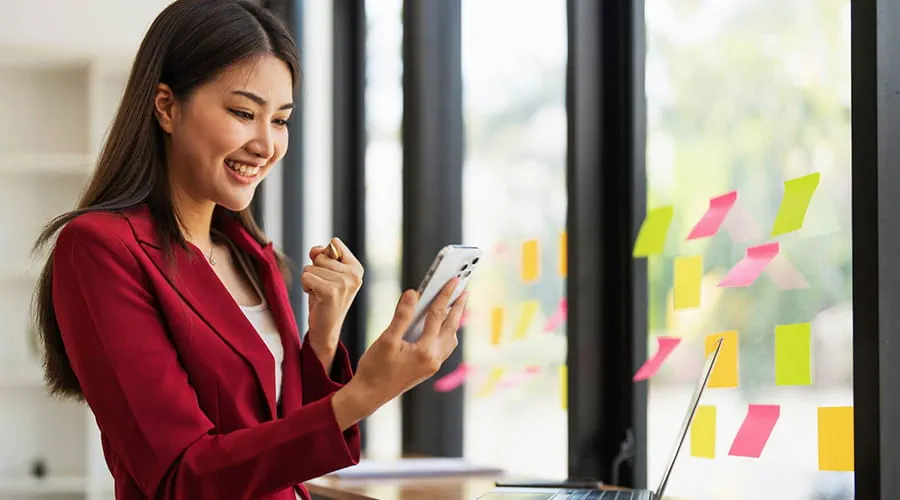 Woman using a mobile phone with a joyful expression