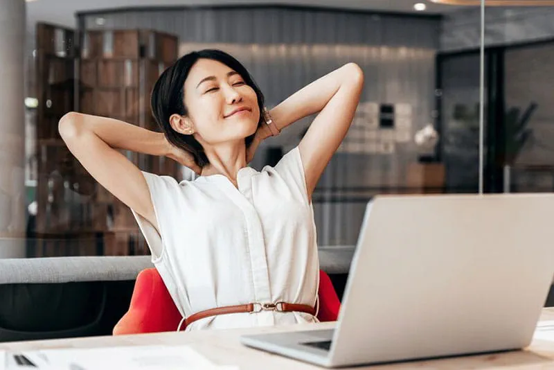 Woman relaxing at her desk after working on a laptop