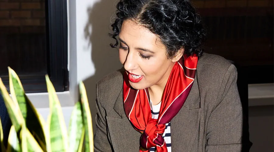 Femme travaillant au bureau avec une plante au premier plan