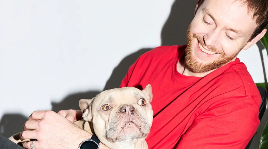 Man houdt hond vast terwijl hij op stoel zit