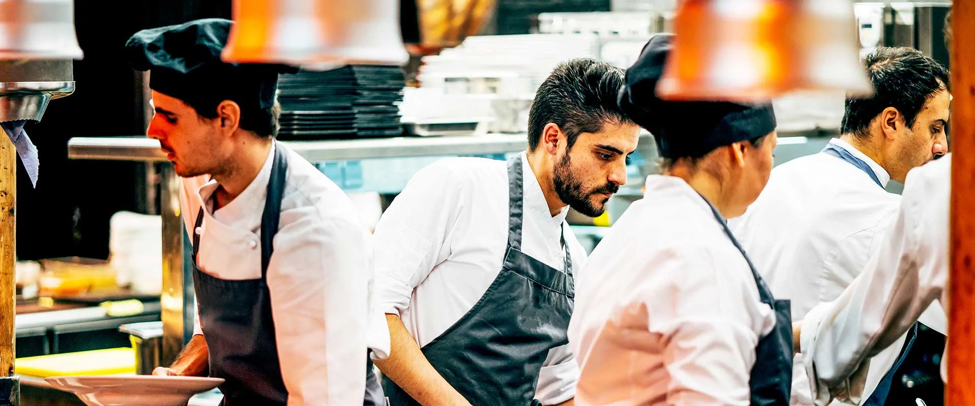 Kitchen team collaborating during busy service in restaurant