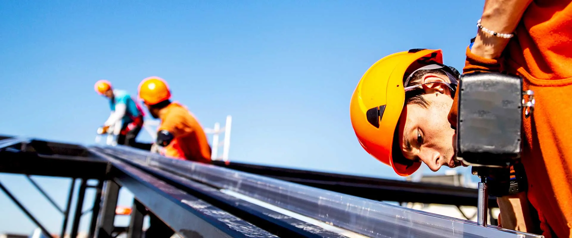 Trabajadores de la construcción instalando paneles solares en la azotea Trabajadores de la construcción instalando paneles solares en la azotea