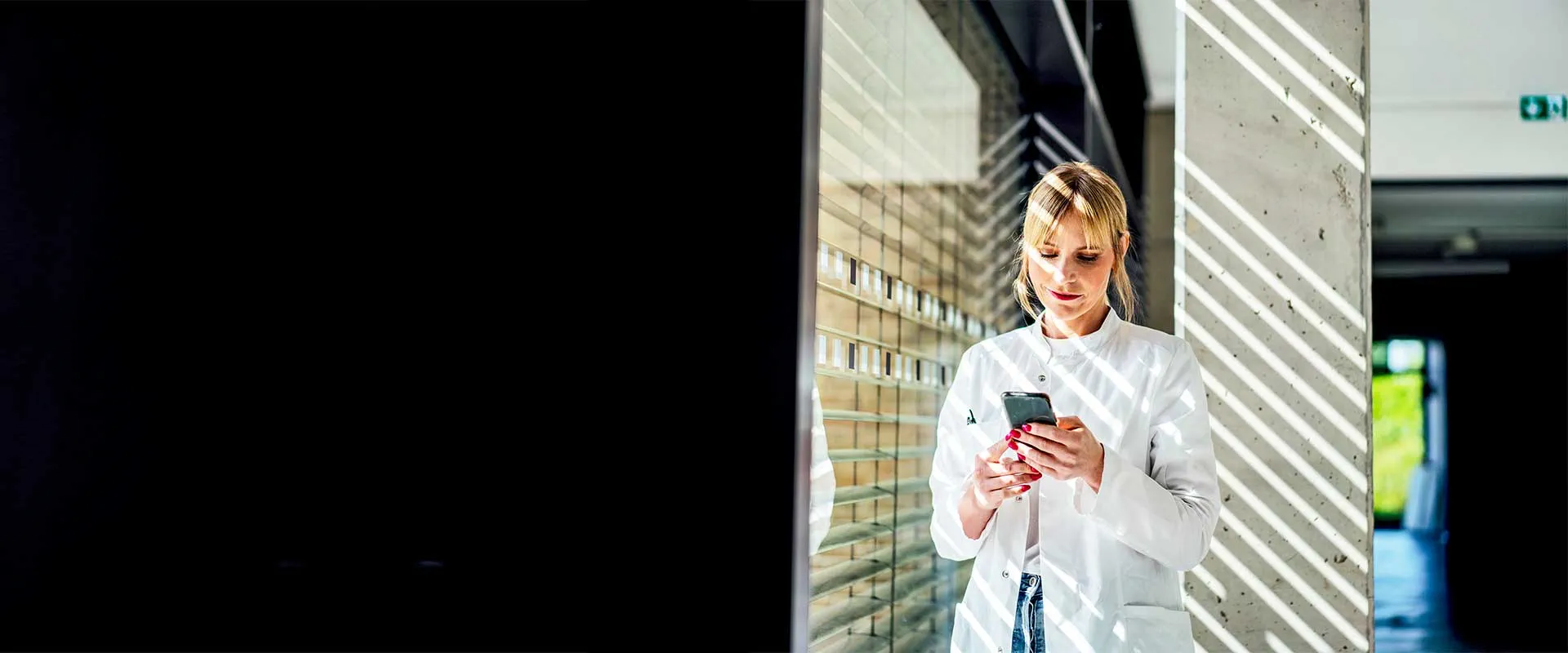 Enfermero usando un teléfono móvil en el pasillo del hospital Enfermero usando un teléfono móvil en el pasillo del hospital