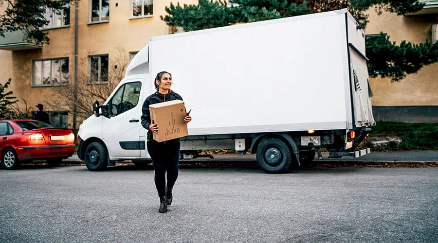 Delivery driver carrying parcel in residential street