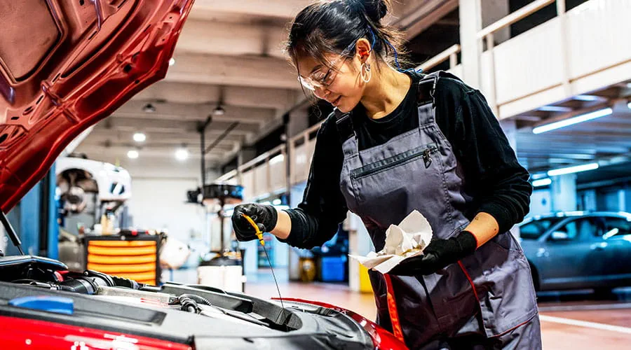 Mecánico trabajando bajo el capó del auto en el garaje