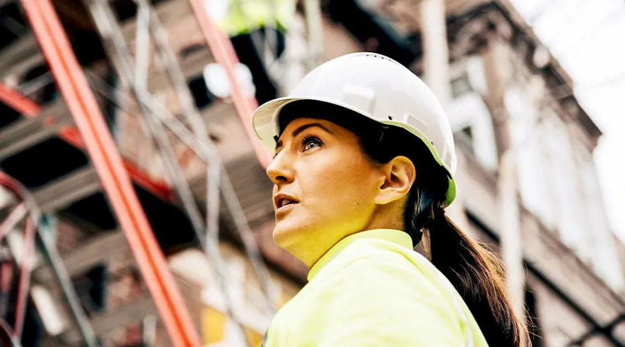 Construction worker looking up at building framework