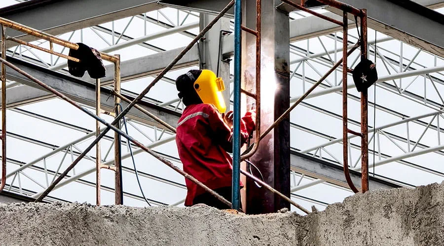 Trabajador en andamio en el sitio de construcción