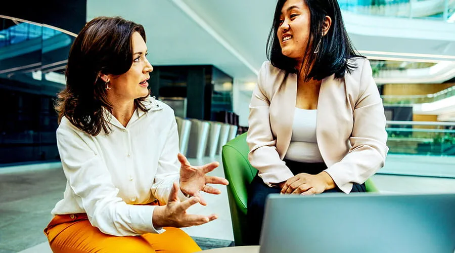 Twee vrouwen bespreken werk aan bureau