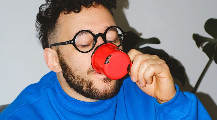 Pessoa a falar num auscultador de telefone vermelho num ambiente de estúdio