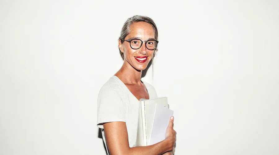 Woman standing and smiling against white background