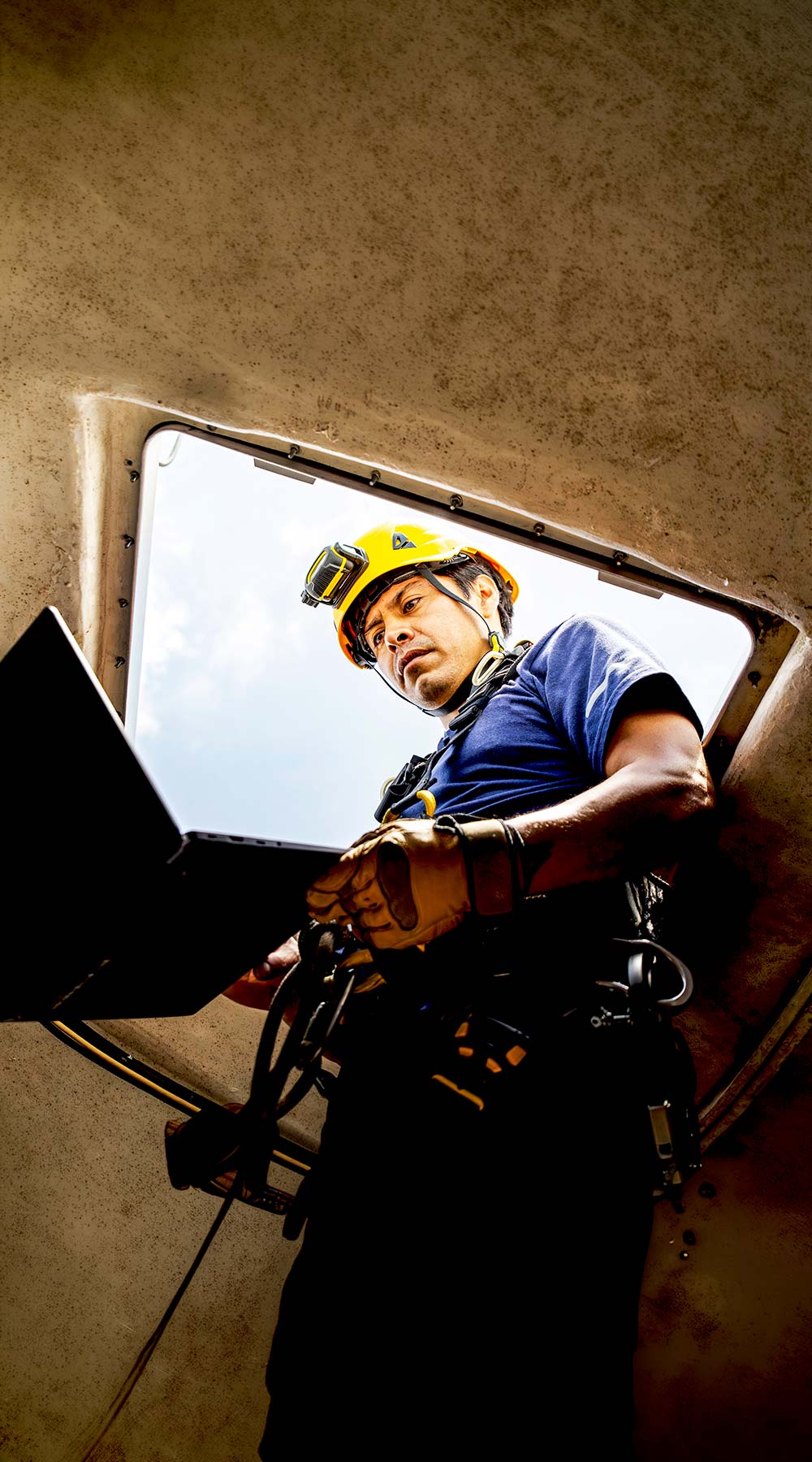 Técnico trabajando con equipo en un espacio confinado Técnico trabajando con equipo en un espacio confinado