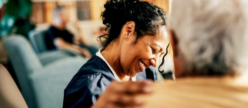 Une soignante souriante communicant avec sa patiente 