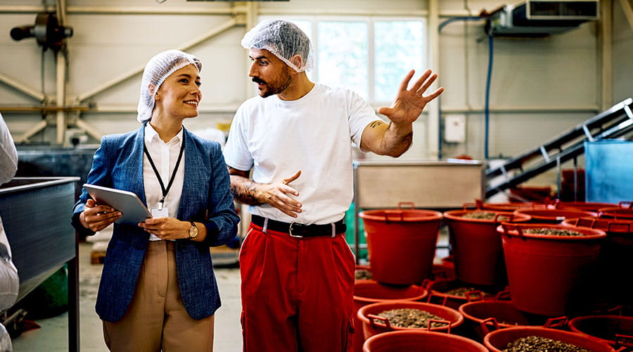 Un Intérimaire agroalimentaire montrant son travail à sa manager dans une usine agroalimentaire