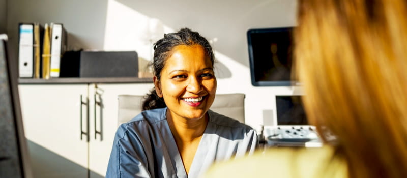 Une professionnelle de santé souriante faisant passer un entretien à une candidate Une professionnelle de santé souriante faisant passer un entretien à une candidate