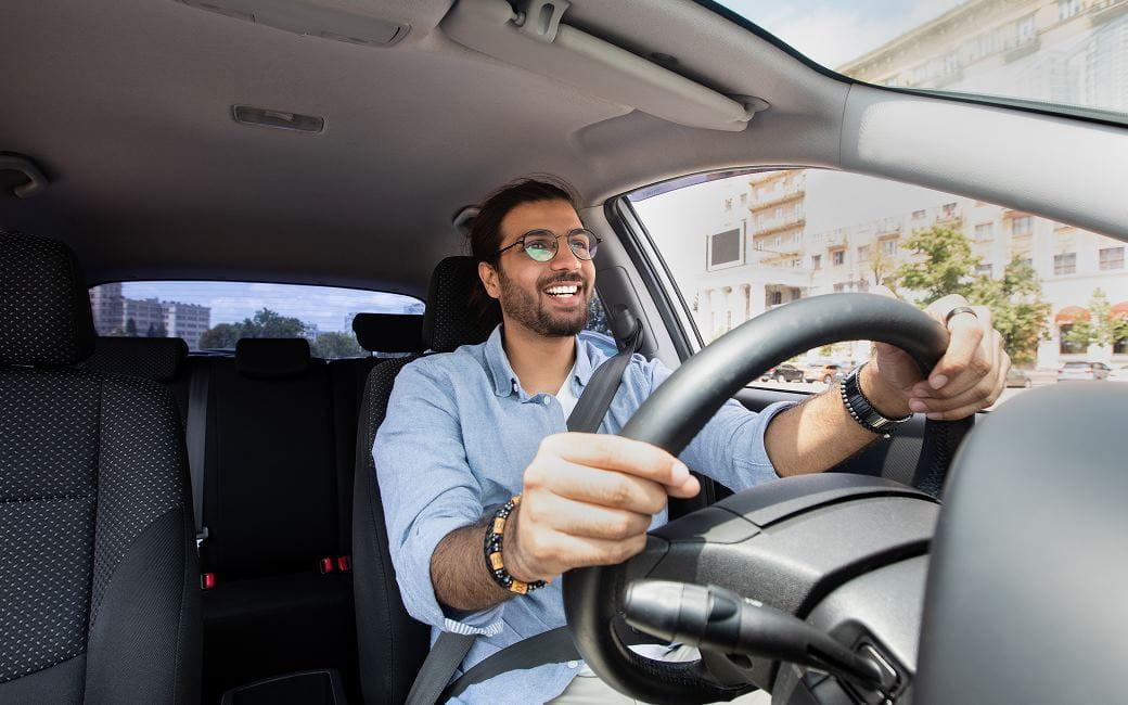 Un homme joyeux conduisant une voiture pour aller au travail Un homme joyeux conduisant une voiture pour aller au travail