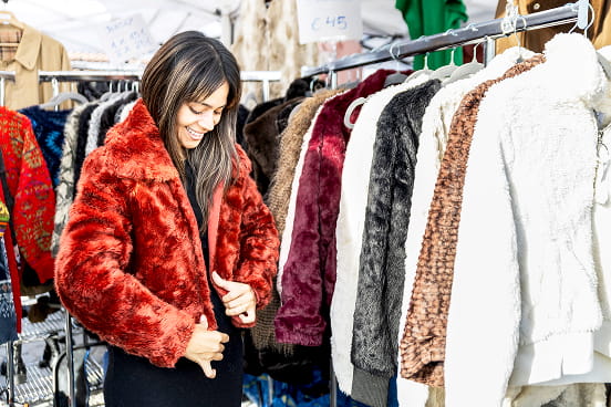 une femme essayant une veste d’hiver rouge en magasin